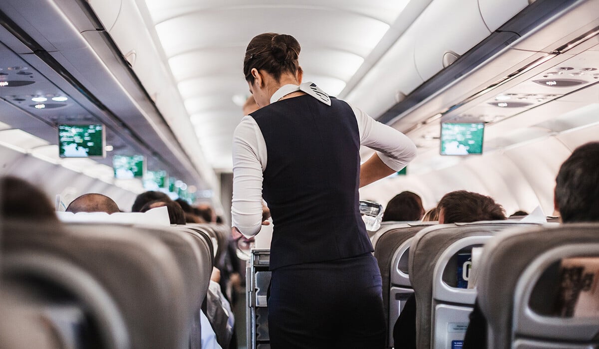 Photo of an airplane stewardess serving drinks to passengers